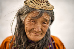 Porträt einer älteren Frau mit Strohhut in Punakha