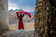 Novize spielt mit seinem Umhang im Wind