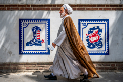 Ein Mullah schreitet vorbei an Propaganda-Graffitis