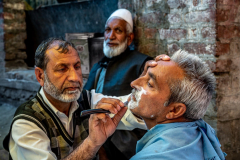 Ein Mann lässt sich auf der Strasse rasieren, Srinagar