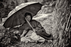 Mutter mit Kind sucht Schutz vor dem Regen am Strassenrand, Bhutan