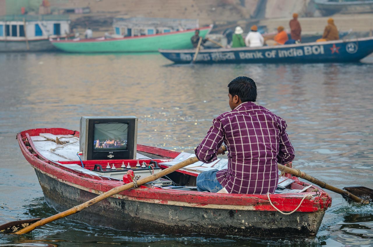 Reisefotografie - Mann mit Fernseher im Boot