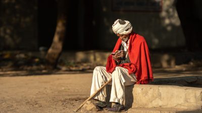 Reisefotografie: Älterer Mann liest in der Morgensonne ein Buch - Gujarat, Indien