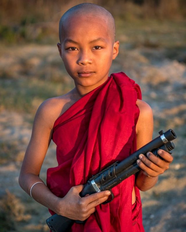 Today is 'Red Hand Day' - the International Day against the Use of Child Soldiers. Which I feel is worthwhile to support. Never the less my photo might be misleading and needs some explanation. I have photographed this young monk in Myanmar and his gun is only a toy. But when I think of what happens in Myanmar since the military coup I am getting very sad and angry. 
And to me it seems that the world's awareness of the horrible things which are going on there is diminishing every day.
I can imagine the people in Myanmar feel left alone and I am not surprised that many turn from a nonviolent resistance to join the guerrilla forces. I am afraid that a long period of civil war lies ahead of Myanmar.
#redhandday #againstchildsoldiers #peopleoftheworld #thepeoplewemet #freemyanmar #lensculture #people_infinity #kings_third_age #irimages #myfeatureshoot #natgeotravel #natgeopeople #somewheremagazine #atlasofhumanity #natgeomyanmar #yourshotphotographer